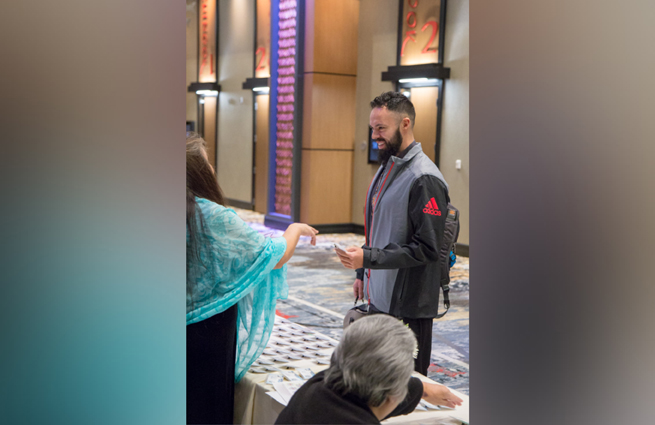 Tulalip Tribes’ 2018 Raising Hands photo of MC speaking with a guest.