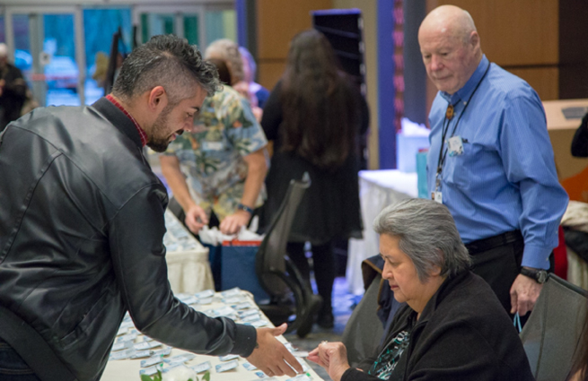 Tulalip Tribes’ 2018 Raising Hands photo of guests exchanging information.