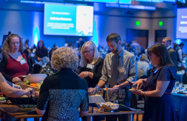 Tulalip Tribes’ 2018 Raising Hands photo of volunteer speaking with a guest.