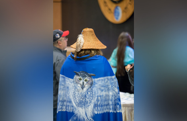 Tulalip Tribes’ 2018 Raising Hands photo of volunteer handing a guest a complimentary gift bag.