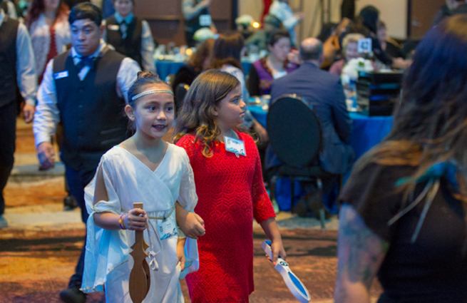 Tulalip Tribes’ 2018 Raising Hands photo of a ceremony with traditional singing, including drumming.