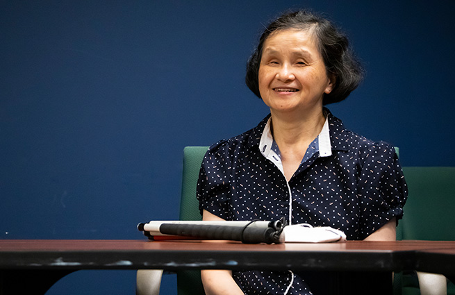 Blind woman, sitting at a table, representing The Lighthouse for the Blind organization 